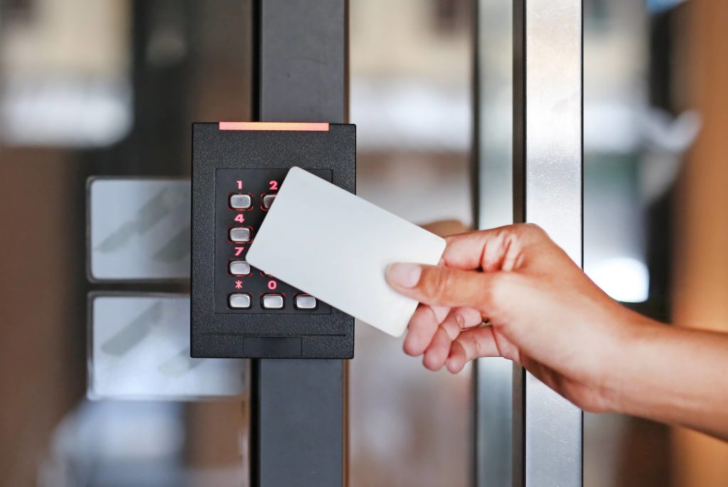 Une utilisatrice passe son badge devant un lecteur de proximité qui lui autorise l'accès